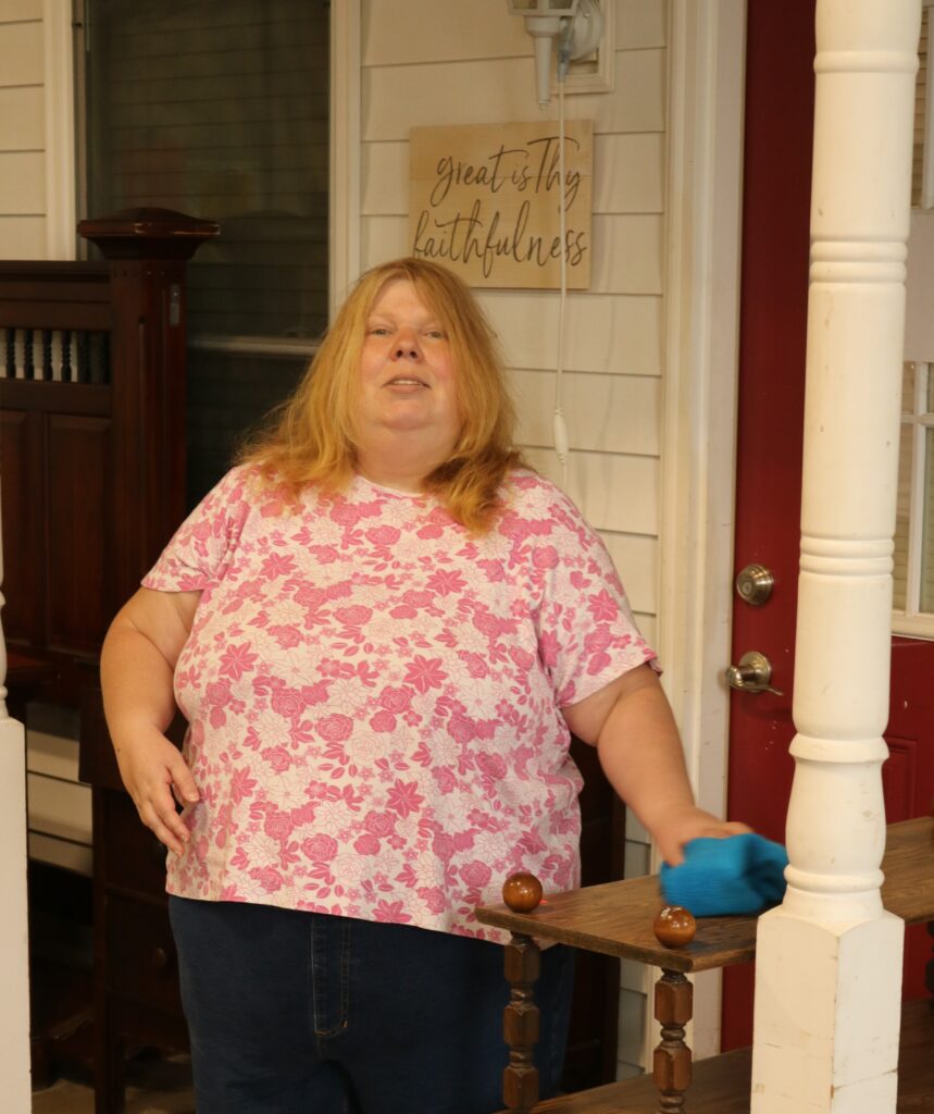 Angela stands smiling while she works at the Re-Store