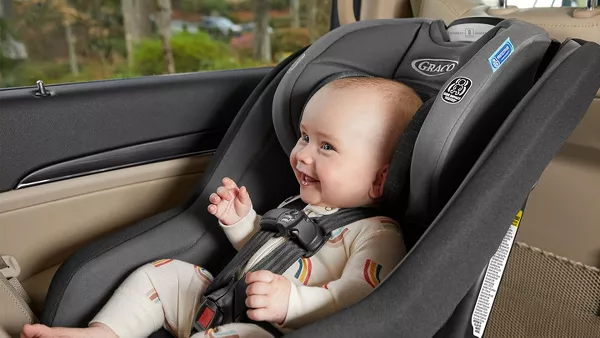 baby smiling while sitting in car seat in car