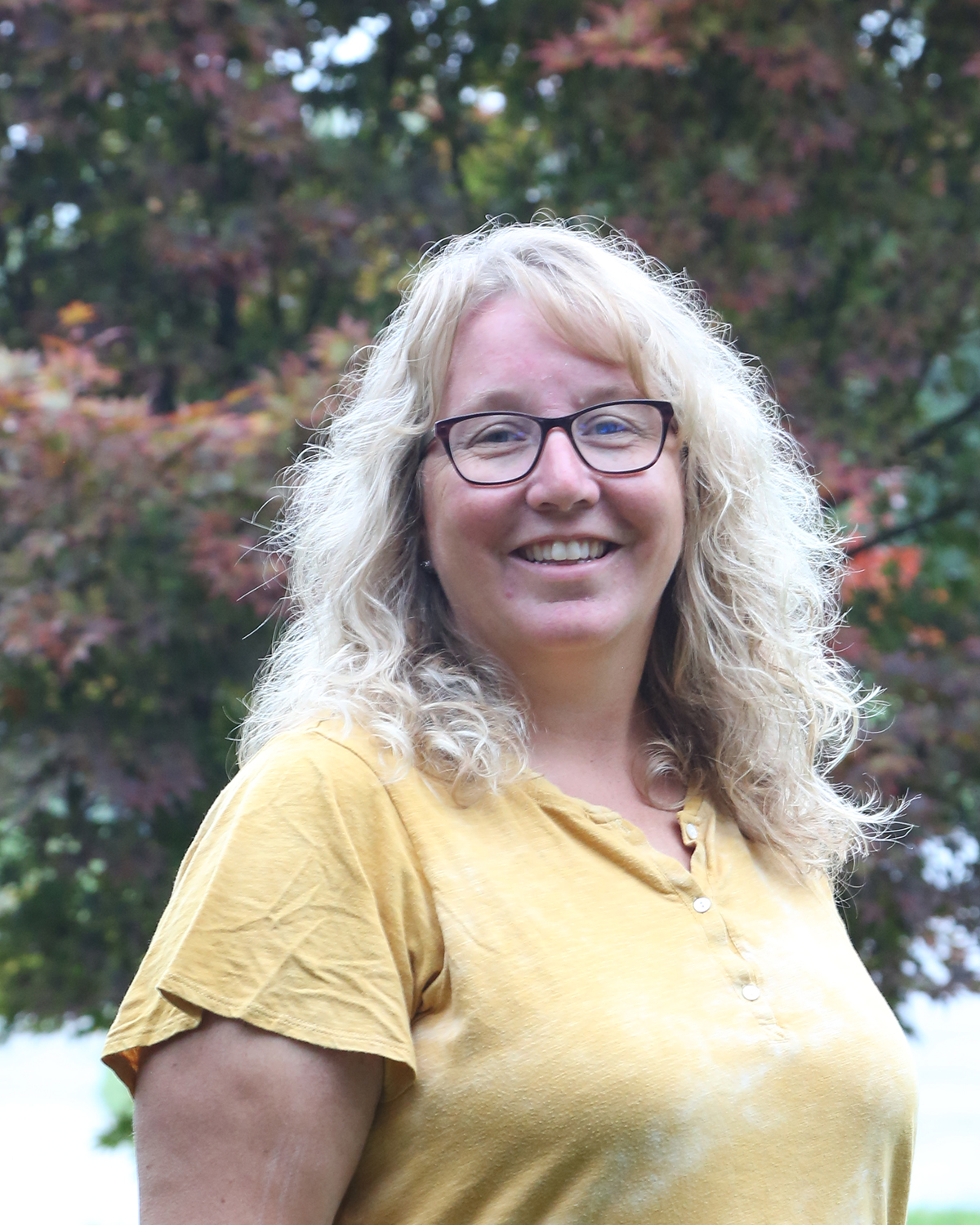 Picture of a woman in yellow smiling