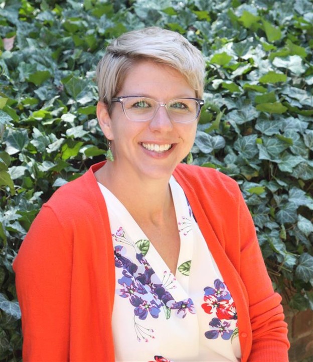 Image of a woman in glasses with red sweater smiling