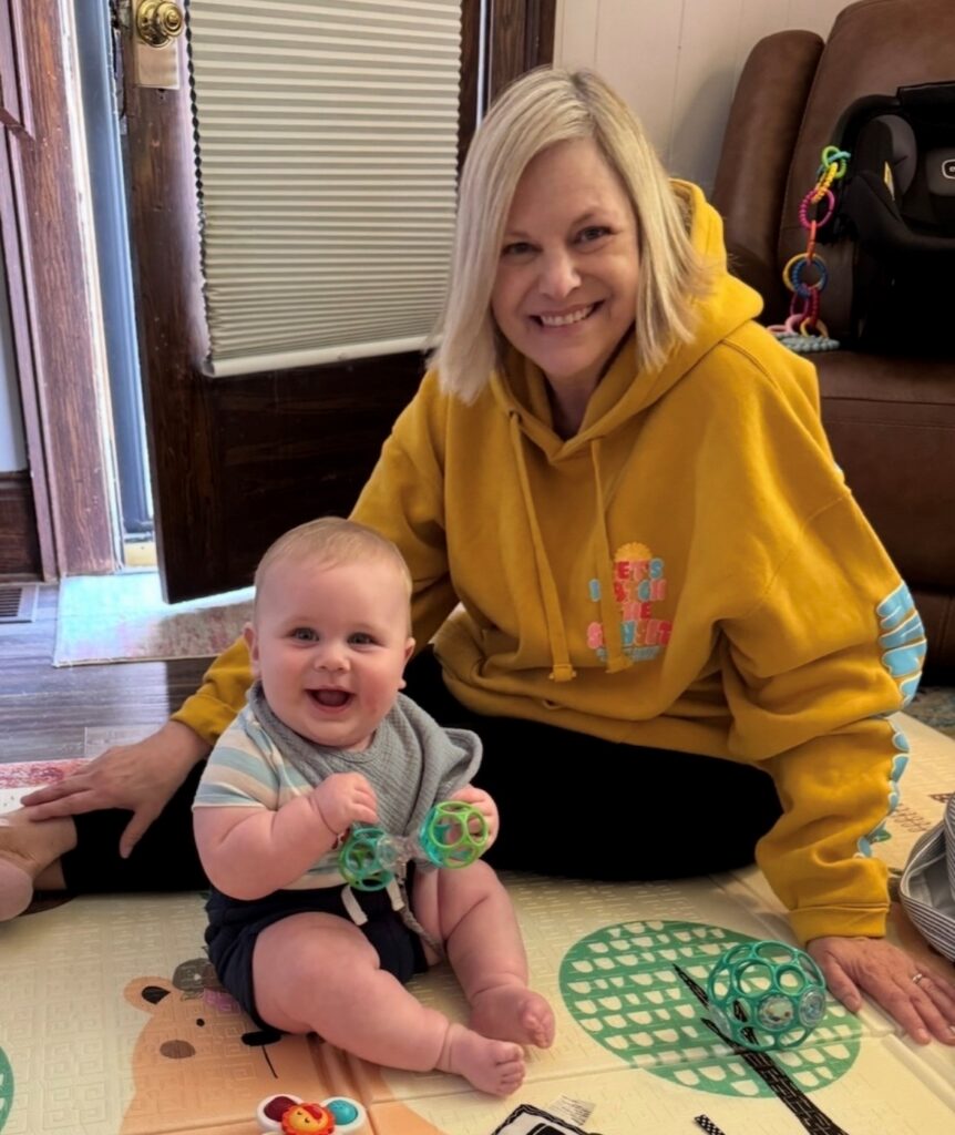 Woman in a yellow shirt with her grandson smiling