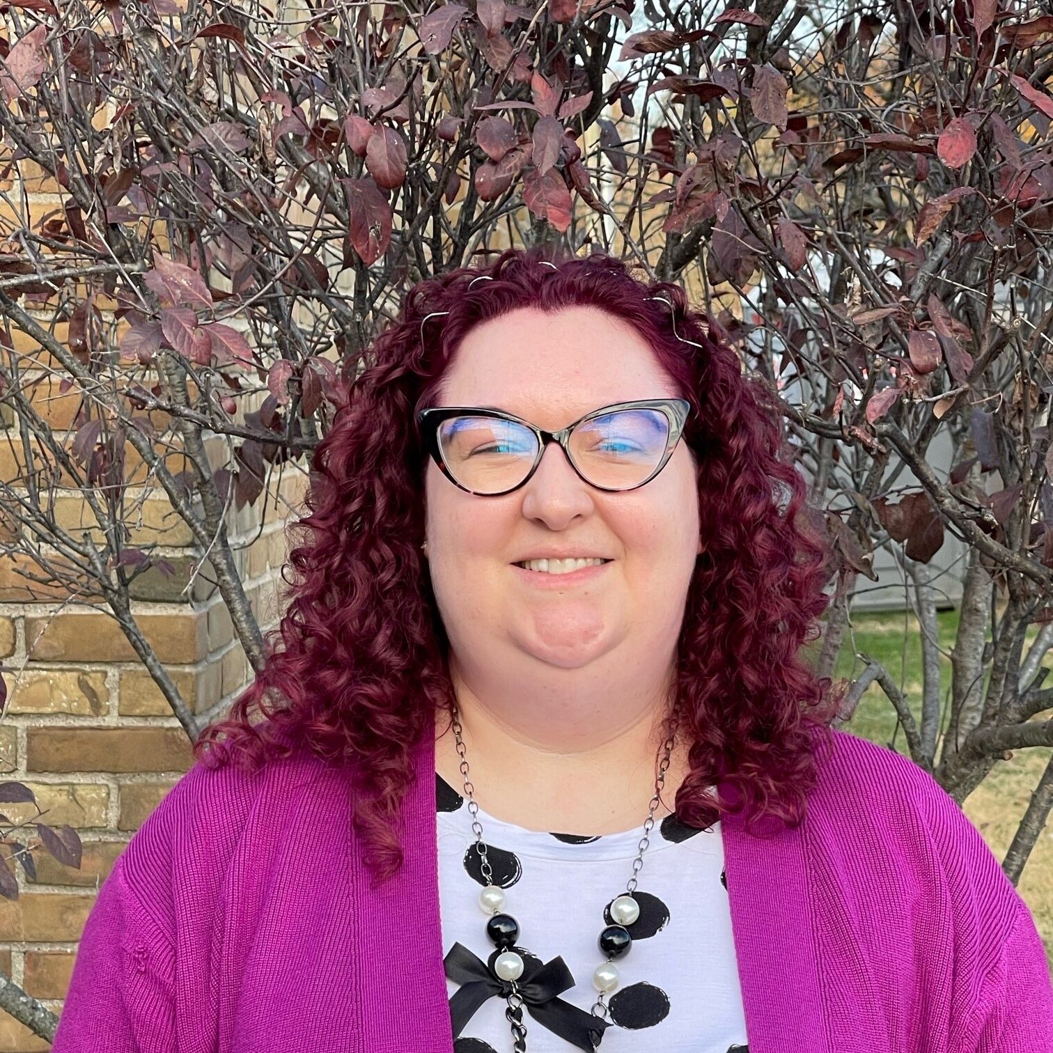 Image of a woman with glasses smiling
