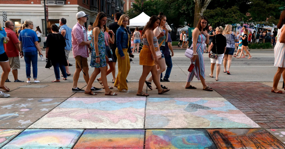 Photo of people walking looking at art during a previous Art Walk.