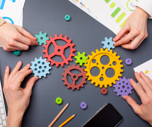 Photo of people collaborating and putting together gears.