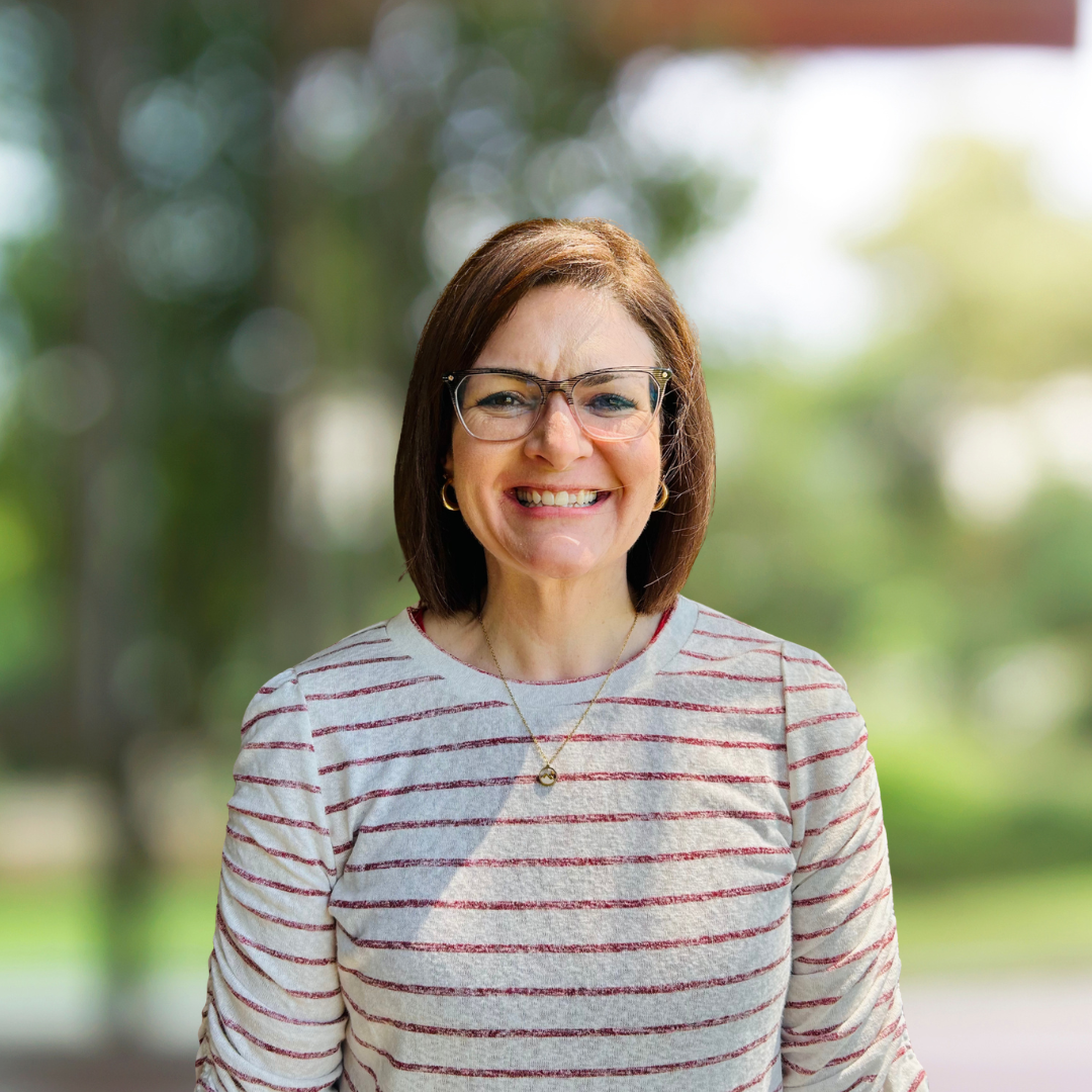 image of a woman in glasses, smiling