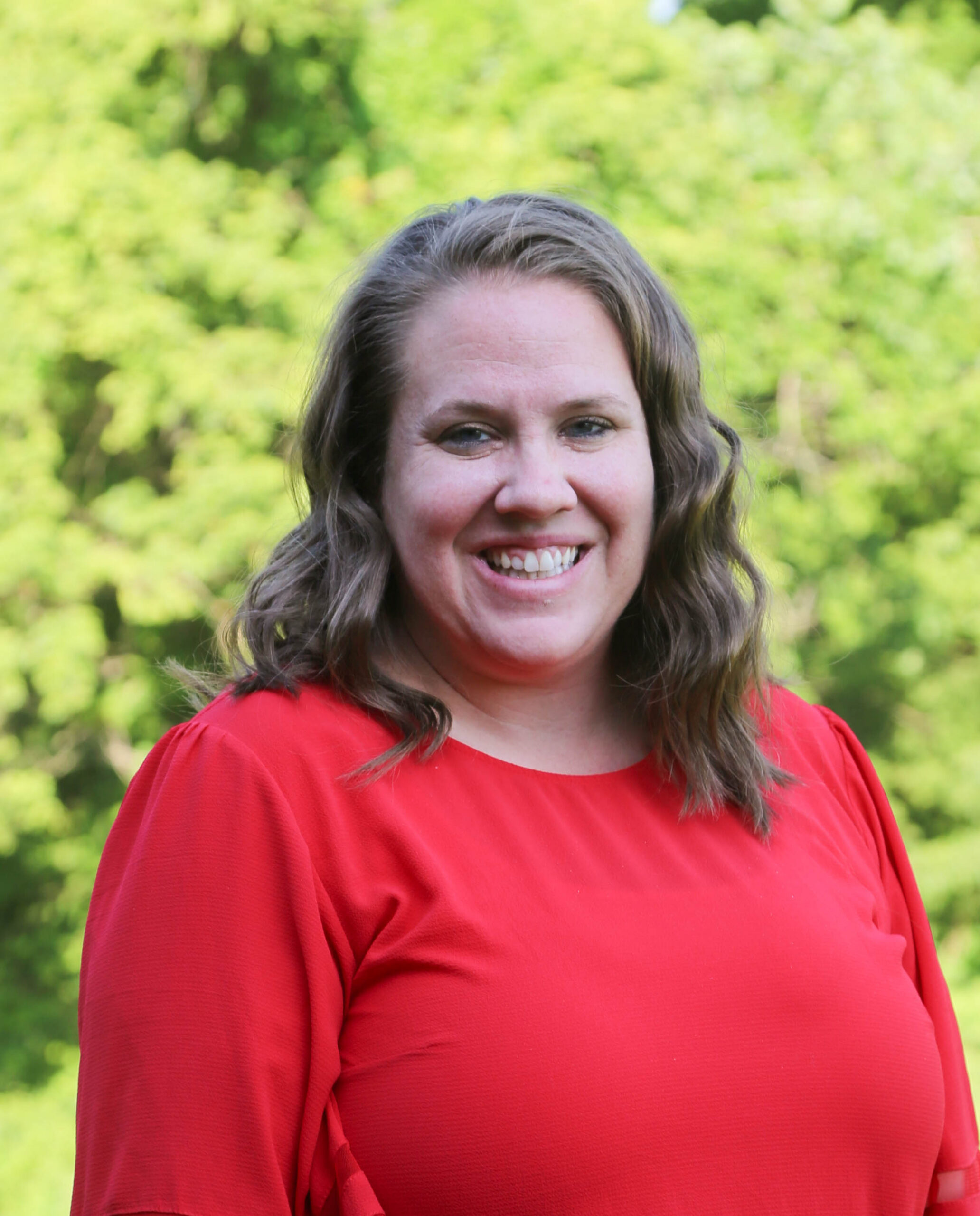 Image of woman with brown hair and a red shirt smiling